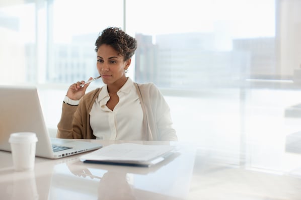 Une femme organisant son e-mail dans Outlook sur son ordinateur portable dans un bureau