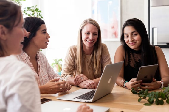 Groupe de femmes rassemblées autour d'un ordinateur portable